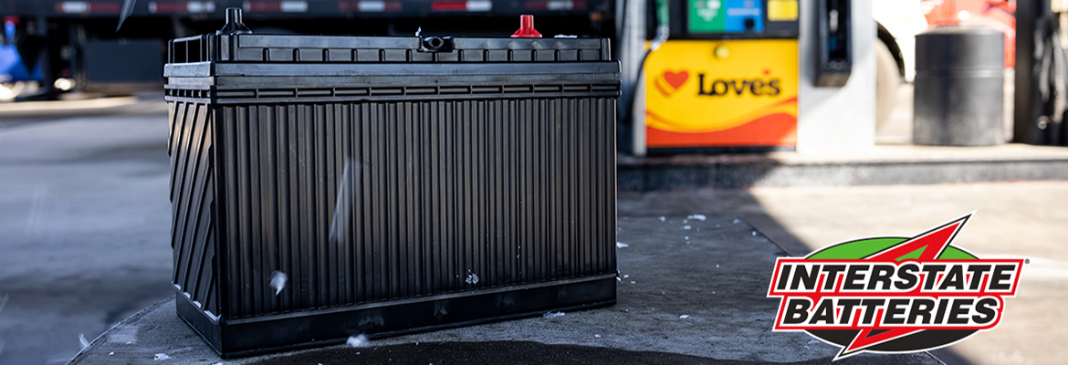 Interstate battery with snow falling next to a diesel pump